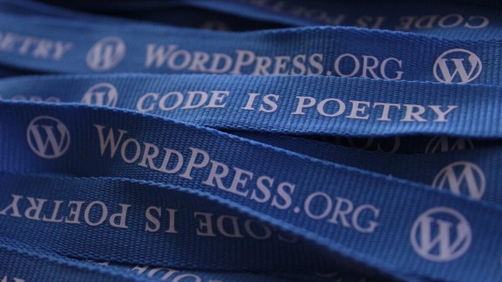 Lanyards showing 'WordPress.org' and 'Code is Poetry'