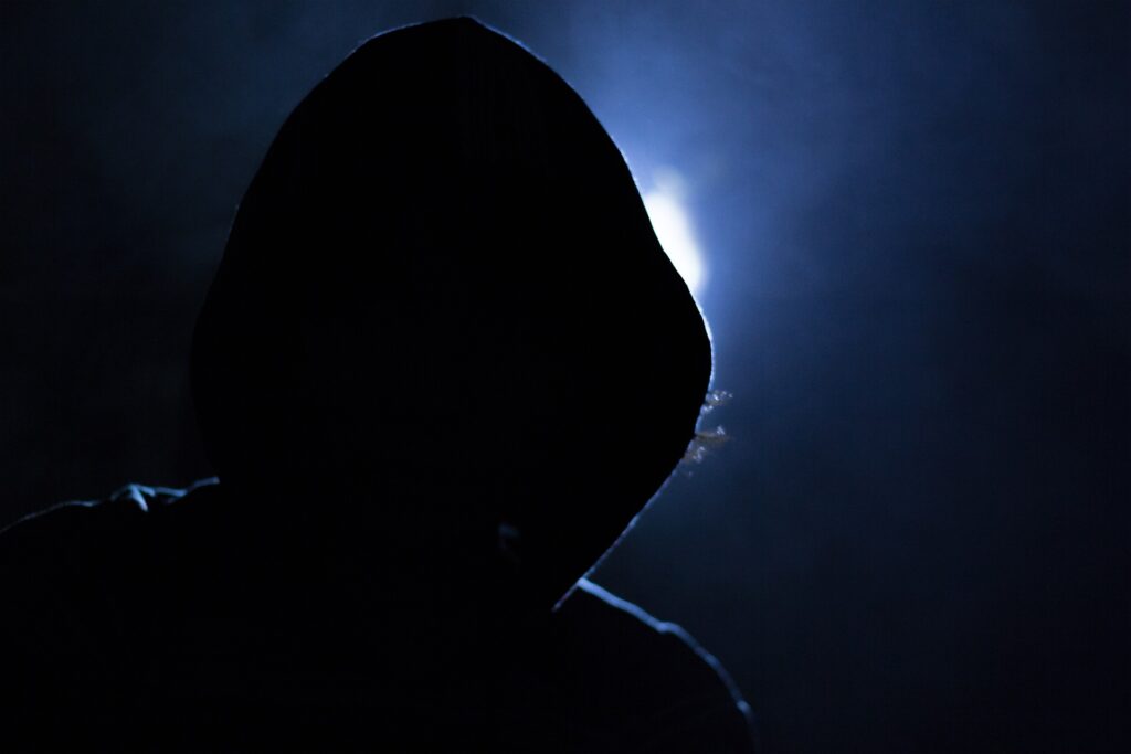 Man in black cloak at night.